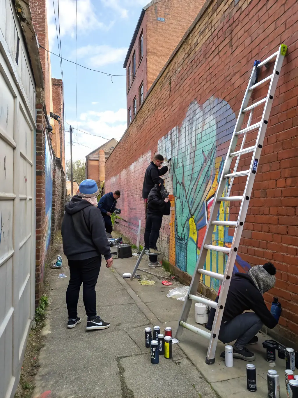 A photograph of a vibrant mural being painted on a community building, illustrating the transformative power of public art.